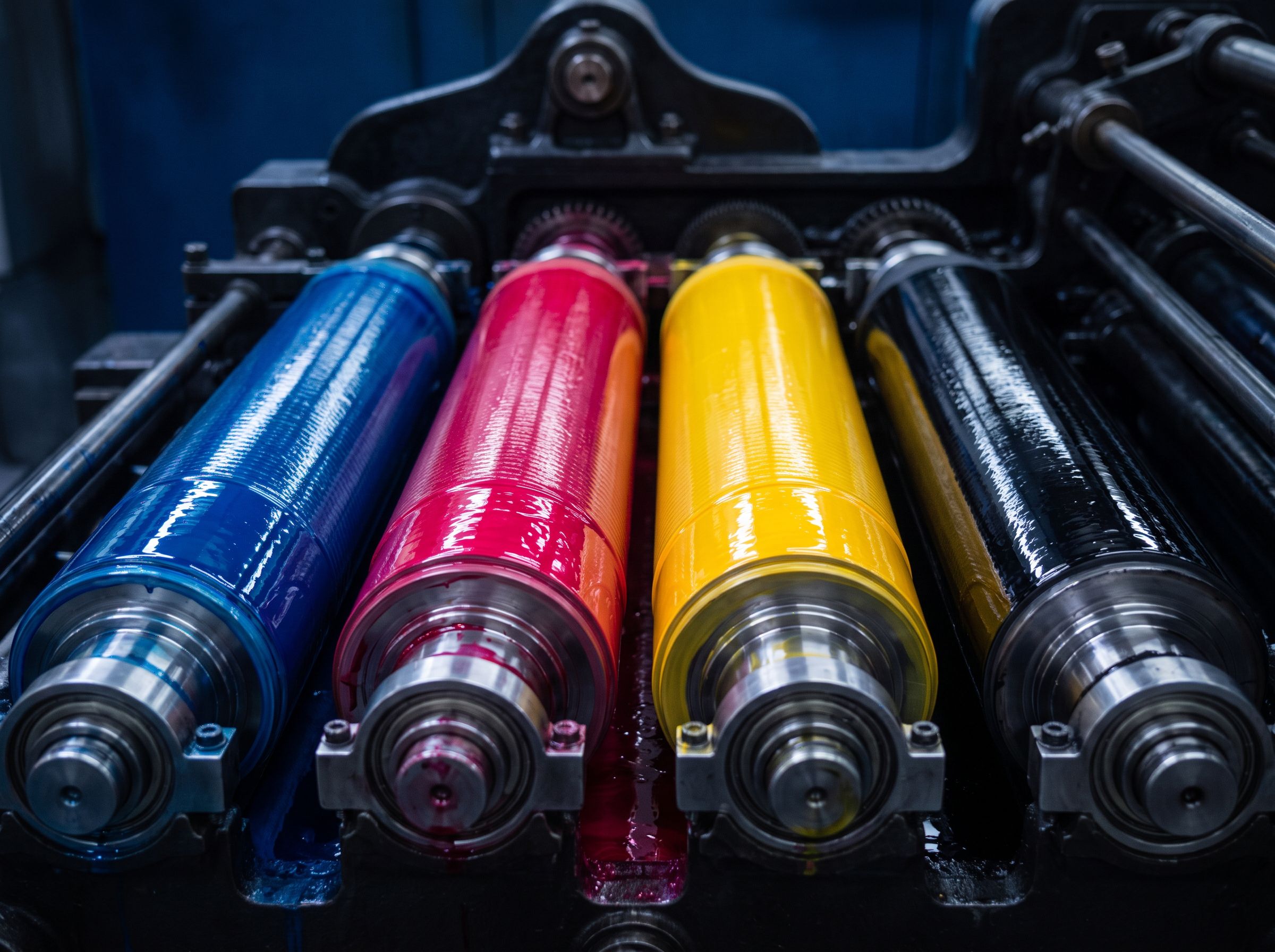 Ink rollers charged with process color. Studio still.